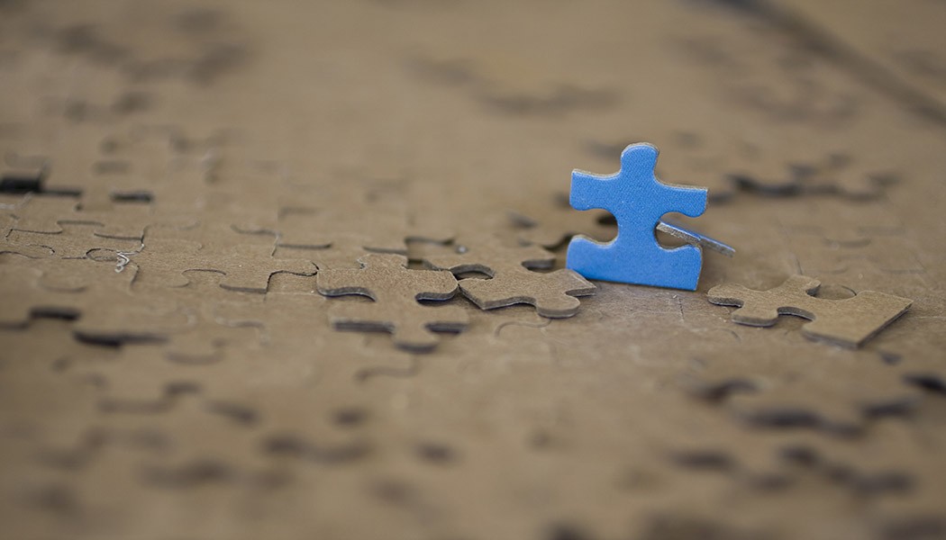 Standing Blue Puzzle Piece on brown blurred background