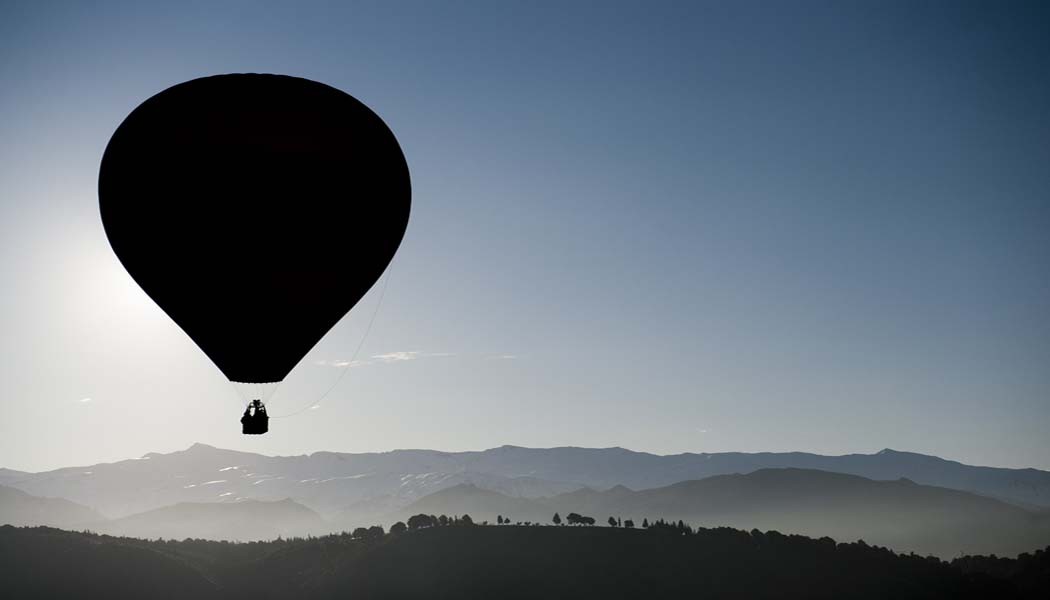 Hot air balloon flying over highest mountains in Spain.